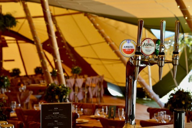 Draught beer pumps on a mobile bar at a tipi wedding in Ardleigh