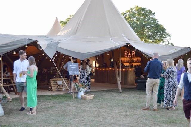 A country style wedding tipi with mobile bar and lights.