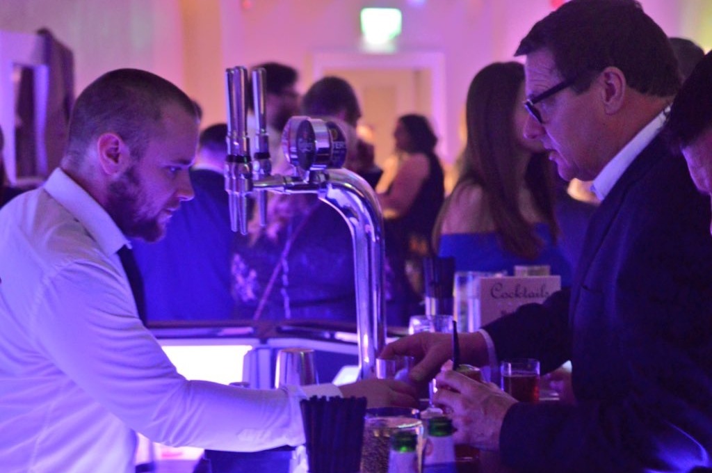 Staff serving customers at a busy mobile bar in Essex